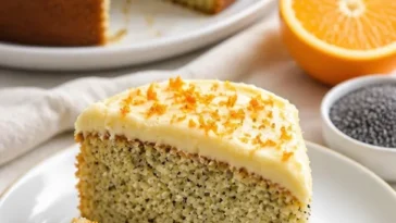Leckerer Orangen-Mohnkuchen auf einem Teller, dekoriert mit Orangenscheiben.