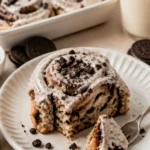 Oreo Zimtschnecken frisch aus dem Ofen, mit Oreo-Stückchen und Zuckerguss dekoriert