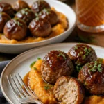 Schweinefleischbällchen mit Süßkartoffelbrei und Bourbon-Ahornsirup-Sauce auf einem Teller.