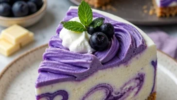 Weißer Schokoladen Cheesecake mit Blaubeeren dekoriert auf einem Teller