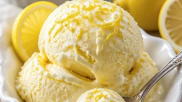 Zitronen gefrorener Joghurt in einer Schale mit frischen Zitronen