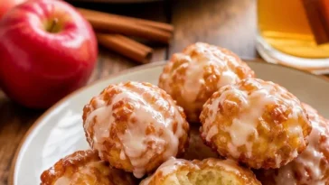 Leckere Apfelpfannkuchen serviert mit Puderzucker und Äpfeln