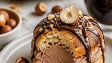 Leckere Creme-Puff-Ringe mit Haselnusscreme auf einem Teller