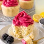 Fluffige Zitronen-Mohn-Cupcakes mit aromatischem Brombeer-Überzug auf einem Teller.