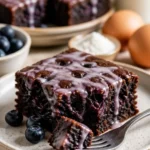 Glasierte Blaubeer-Brownies auf einem Teller, saftig und verführerisch.