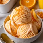 Hausgemachtes Orangen-Eiscreme in einer Waffel mit frischen Orangenstücken