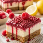 Himbeer-Cheesecake-Riegel auf einem Teller mit frischen Himbeeren