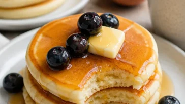 Fluffige Japanische Pfannkuchen serviert mit frischen Früchten und Sirup