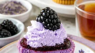 Mini Schwarzbeeren-Lavendel-Käsekuchen auf einem weißen Teller