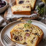Schinken Brot mit Oliven und Käse auf einem Holzbrett angerichtet