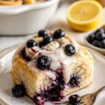 Zitronen-Blaubeer-Süßschnecken auf einem Backblech, frisch gebacken.