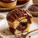 Donauwellen-Muffins mit Schokobons-Füllung auf einem rustikalen Tisch