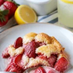 Leckerer Erdbeer-Cobbler frisch aus dem Ofen, serviert mit Sahne.
