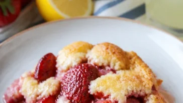 Leckerer Erdbeer-Cobbler frisch aus dem Ofen, serviert mit Sahne.