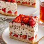 Erdbeer-Stracciatella-Torte auf einem Teller mit frischen Erdbeeren und Schokoladensplittern