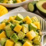 Gurkensalat mit Mango und Avocado auf einem Teller