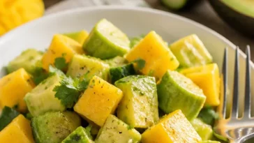 Gurkensalat mit Mango und Avocado auf einem Teller