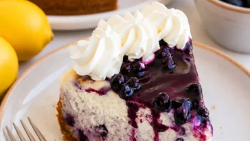 Hausgemachter Blaubeerkäsekuchen mit frischen Blaubeeren auf einem Teller