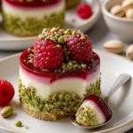 Mini Himbeer- und Pistazienmousse-Torte mit frischen Himbeeren und Pistazien