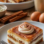 Zimtrollen-Cheesecake-Riegel auf einem weißen Teller, appetitlich angerichtet.