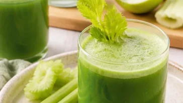 Glas Sellerie-Apfel-Saft auf Holzoberfläche, gesundes Getränk