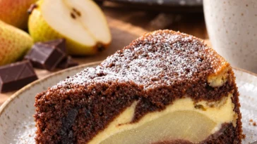 Leckerer Birnenkuchen mit Schmand und Schokoboden auf einem Teller