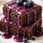 Glasierte Heidelbeer-Brownies auf einem Teller, ein verführerisches Dessert.