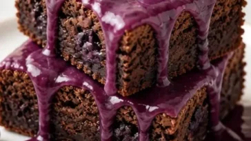 Glasierte Heidelbeer-Brownies auf einem Teller, ein verführerisches Dessert.