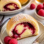 Himbeer-Pudding-Brötchen auf einem Teller, frisch gebacken und attraktiv angerichtet.