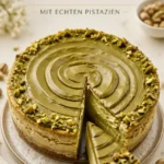 Pistazien-Käsekuchen auf einem Teller, dekoriert mit frischen Pistazien