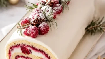 Weihnachts-Himbeerkuchenrolle mit frischen Himbeeren und Sahnefüllung