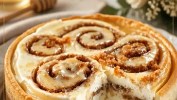 Frisch gebackene Zimtschnecken, Honigkipferl und Käsekuchen auf einem Teller