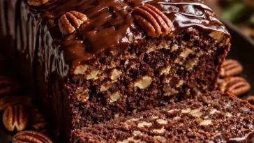 Dekadentes Schokoladen-Pekan-Nuss-Brot frisch gebacken auf einem Holzbrett.
