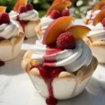 Pfirsich-Melba-Baiserschalen mit frischen Pfirsichen und Sahne
