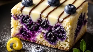 Blaubeer-Zitronen-Kekse mit weißer Schokoladensauce auf einem Teller